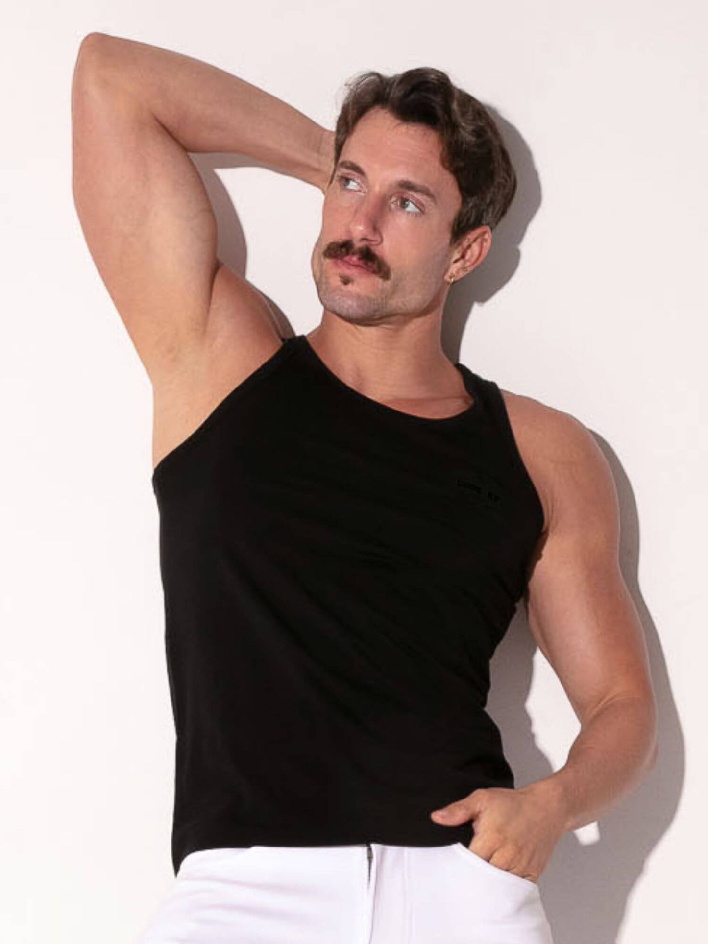 Man wearing a black tank top against a white background