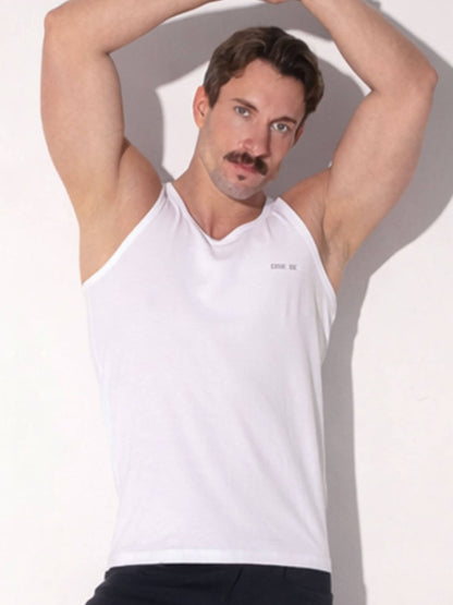 Man wearing a white tank top with text on a plain background