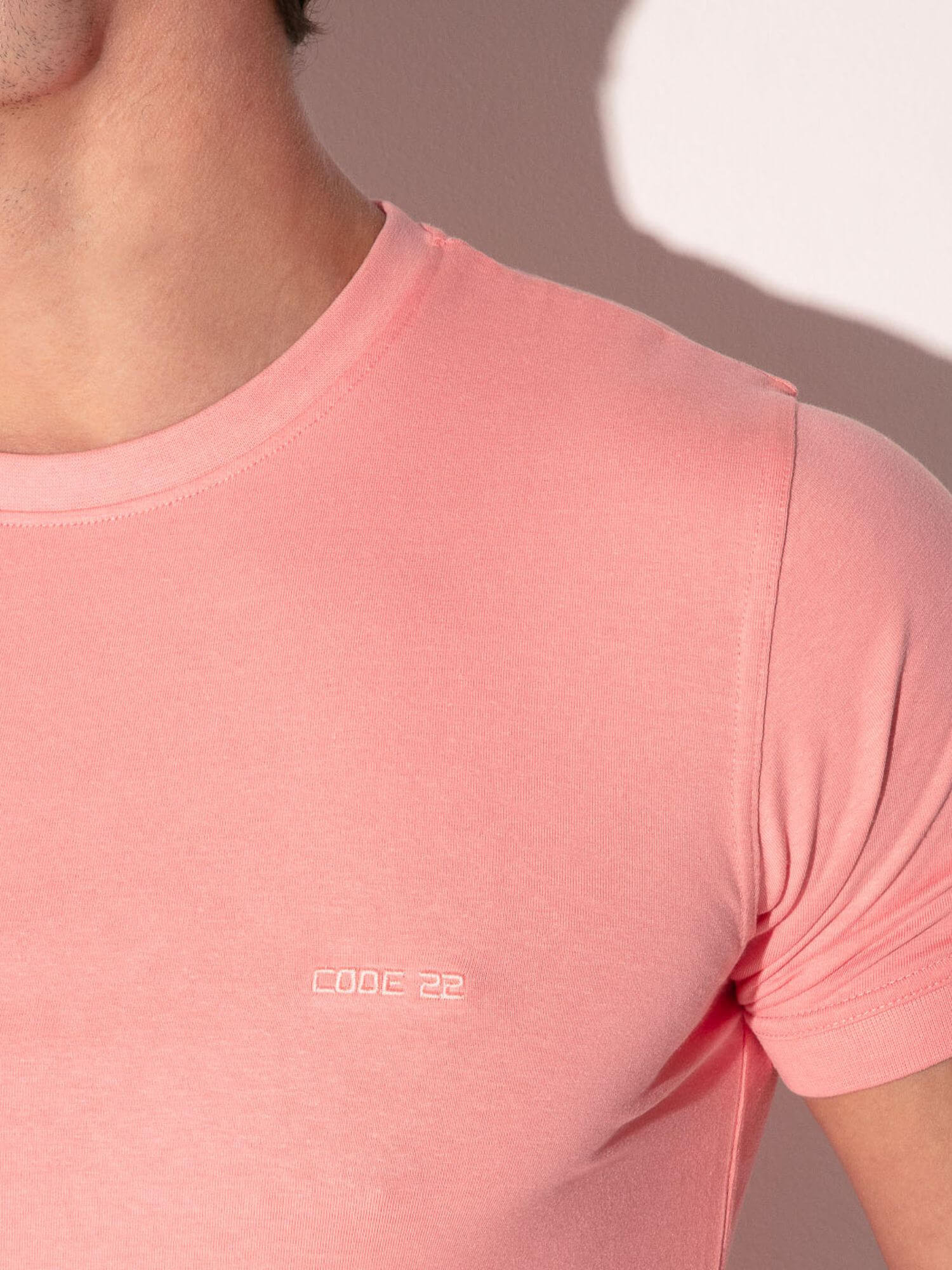 Close-up of a person wearing a pink t-shirt with 'COOC 22' branding.