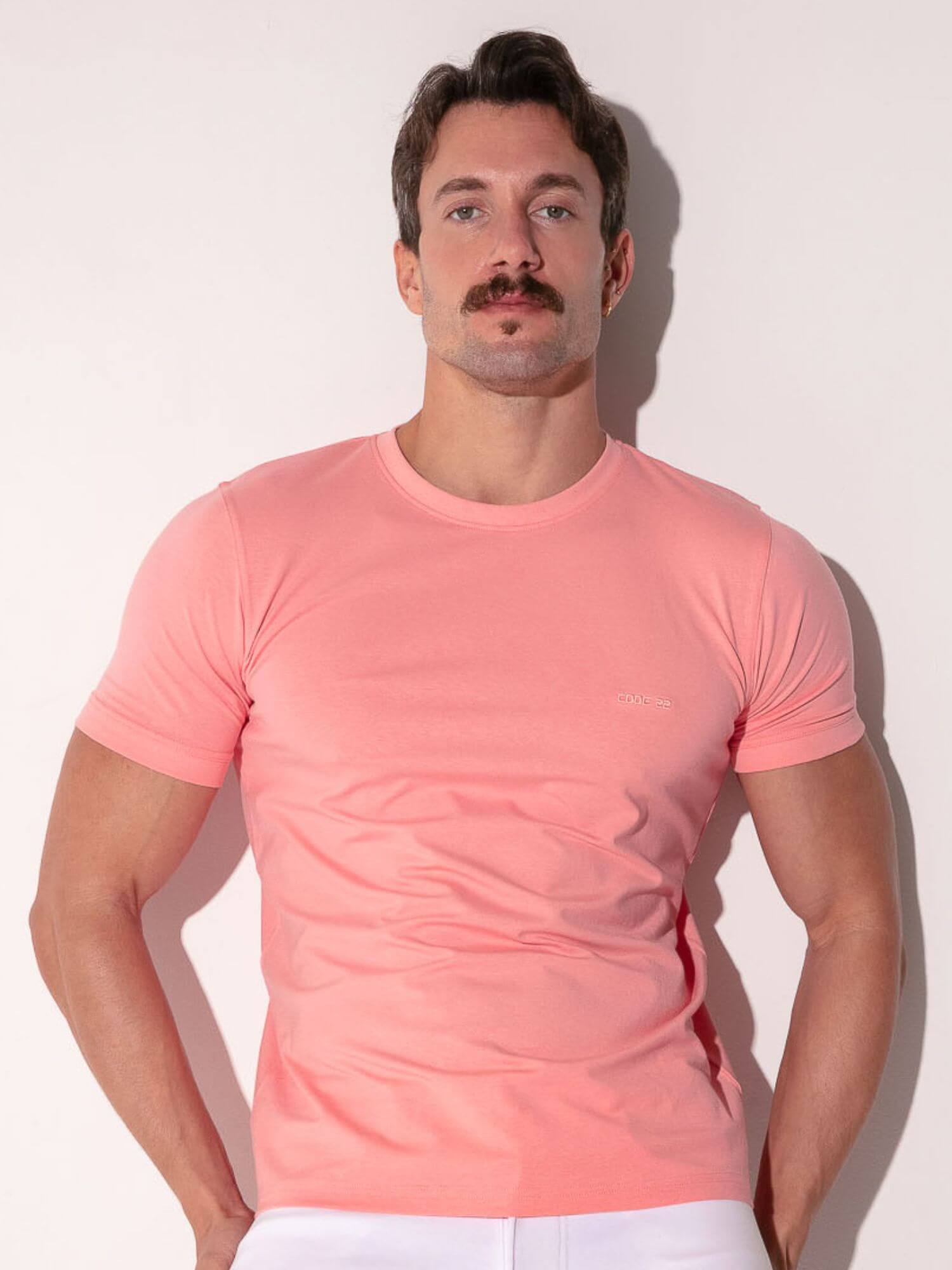 Man wearing a pink t-shirt against a white background