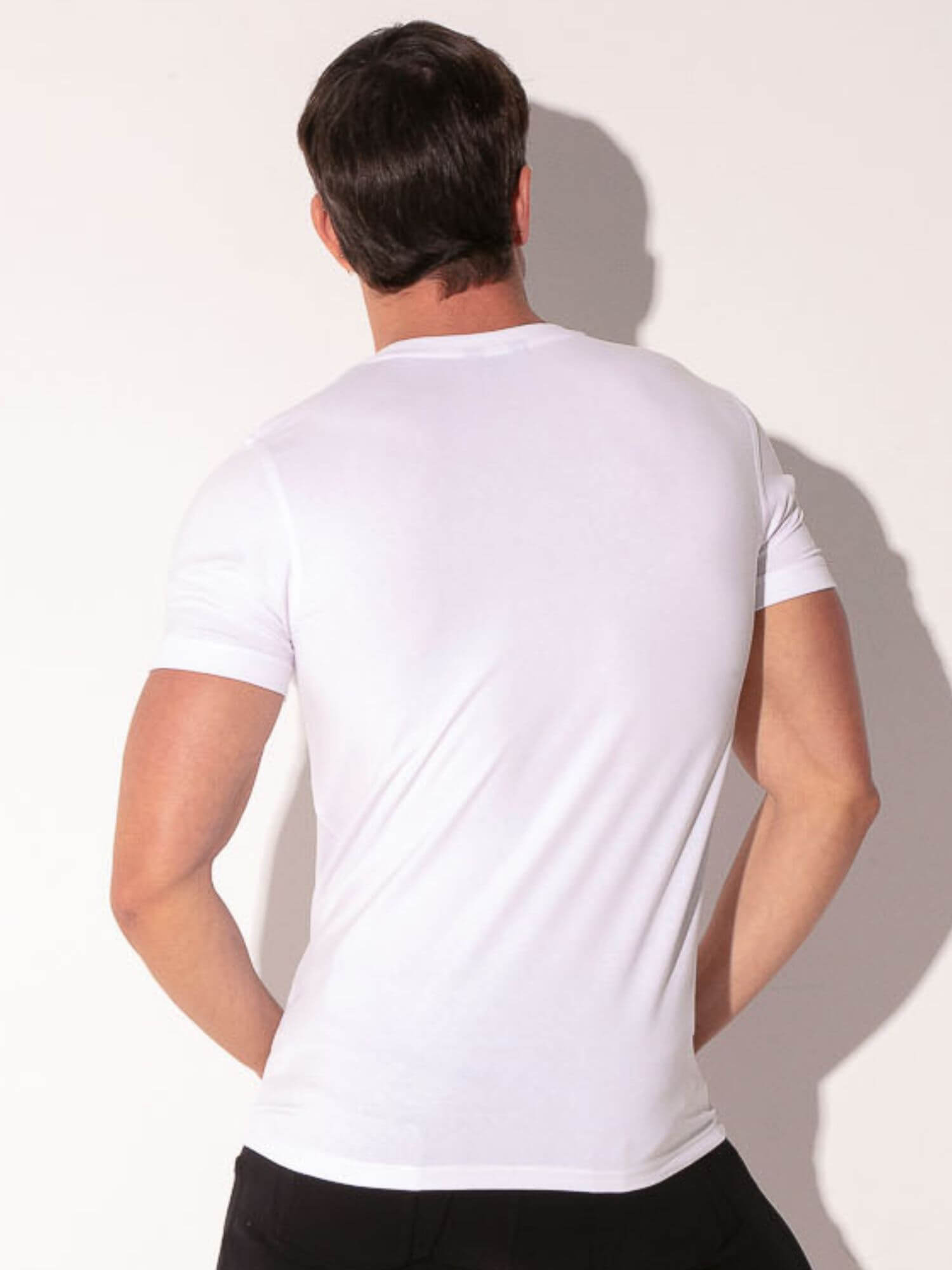 Man wearing a plain white t-shirt against a light background