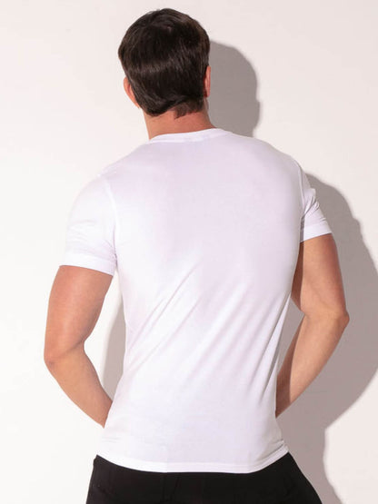 Man wearing a plain white t-shirt against a light background