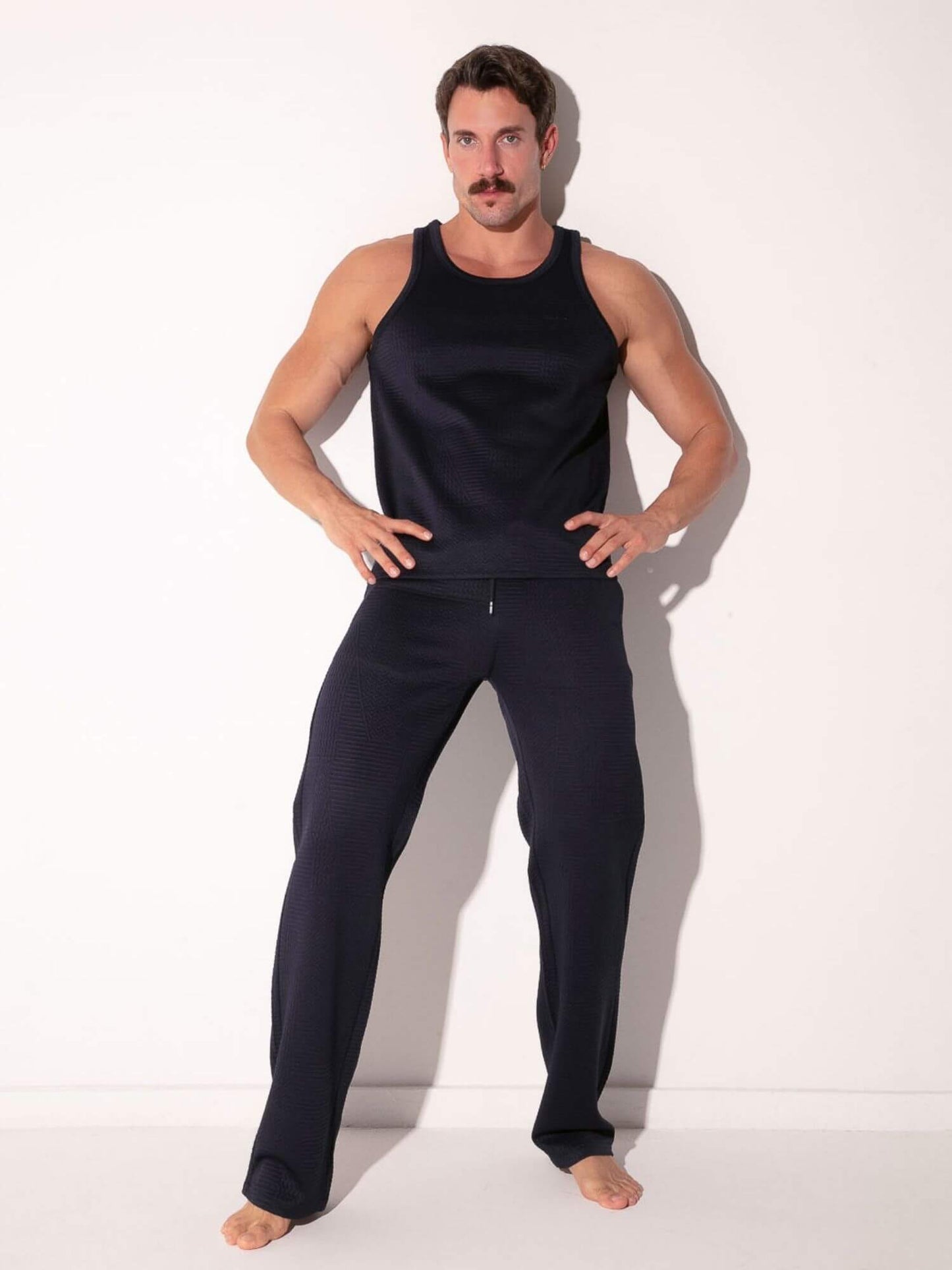 man wearing navy code 22 medley tank top and pants