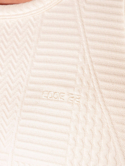 Close-up of a textured beige fabric with a brand logo.
