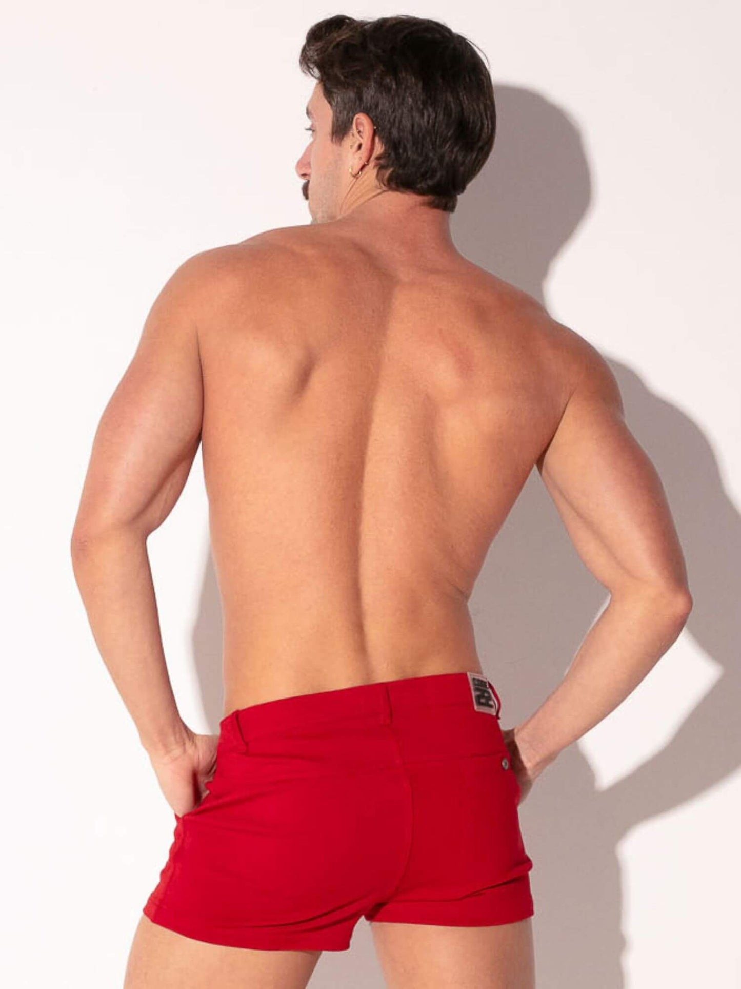 Man wearing red shorts against a white background