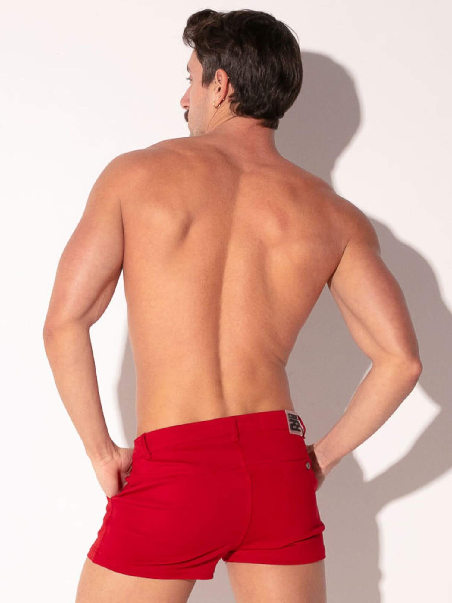 Man wearing red shorts against a white background