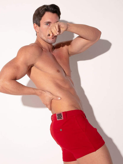 Man wearing red mini shorts on a white background