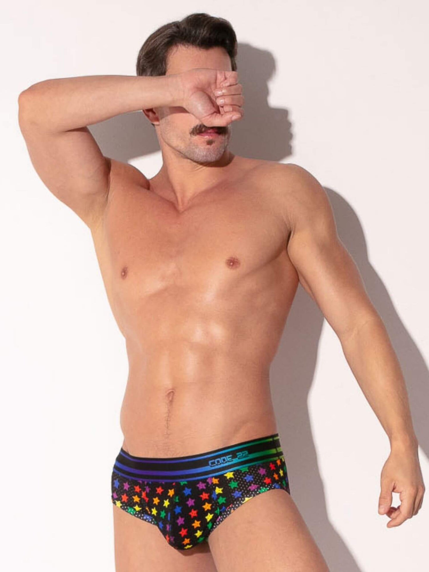 Man wearing colorful star-patterned underwear against a white background