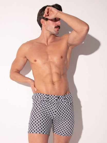 Man wearing patterned shorts against a plain background