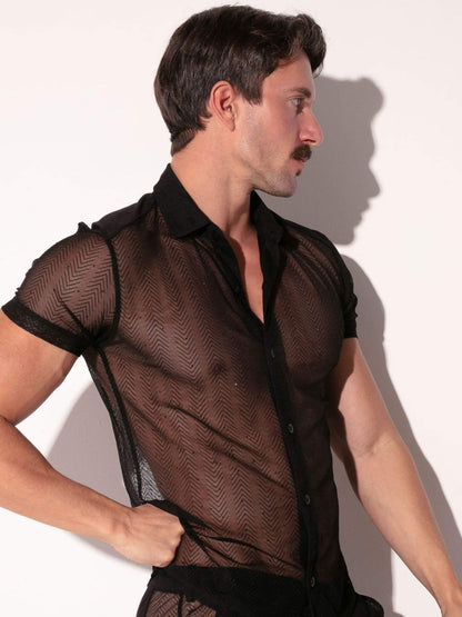 Man wearing a sheer black shirt against a white background