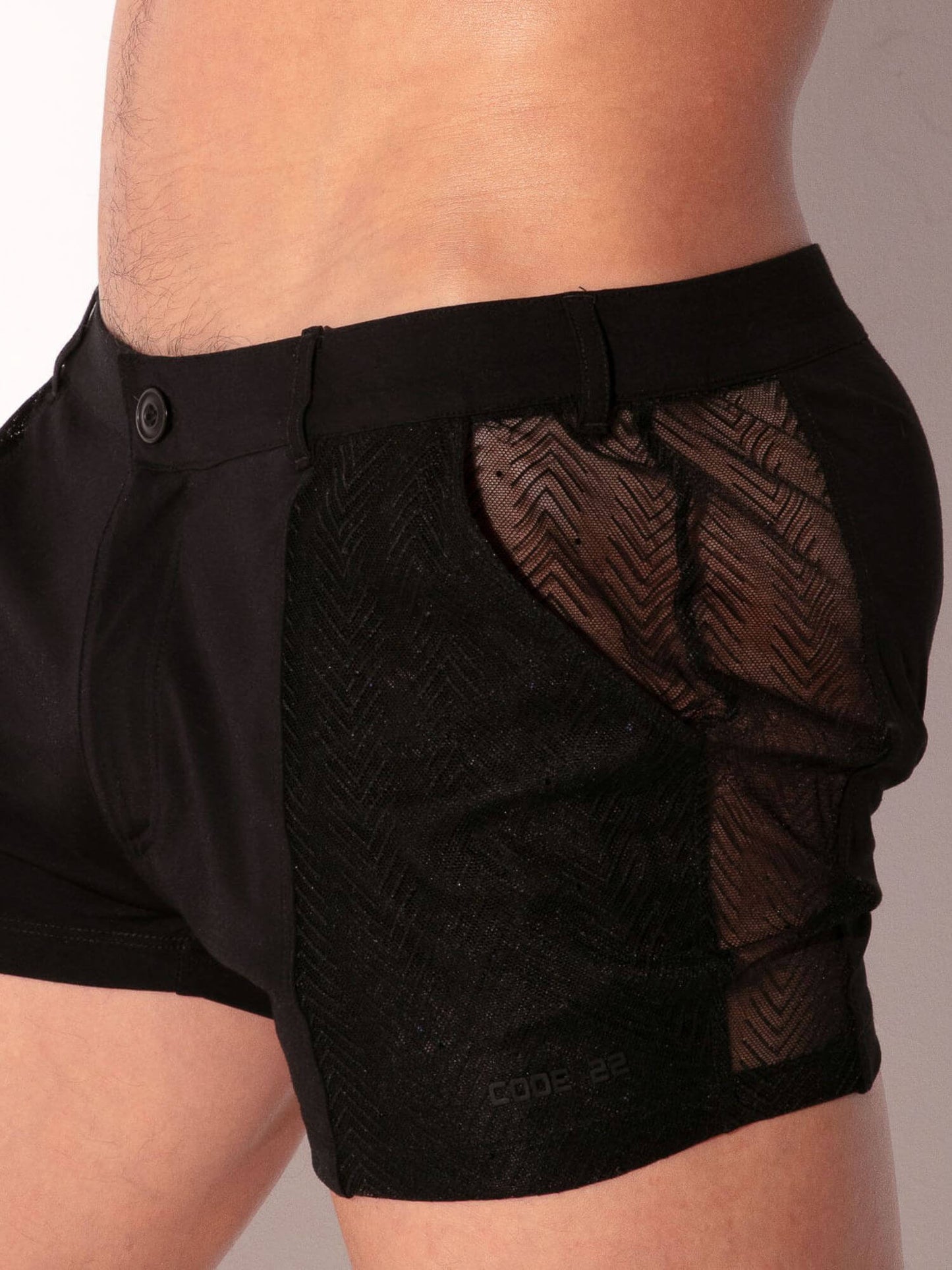 Black athletic shorts with mesh panels on a neutral background