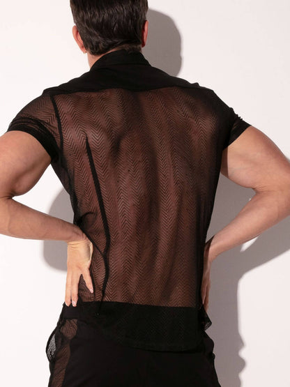 Person wearing a sheer black top with a plain background