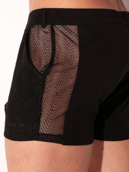 Black athletic shorts with mesh panels on a white background