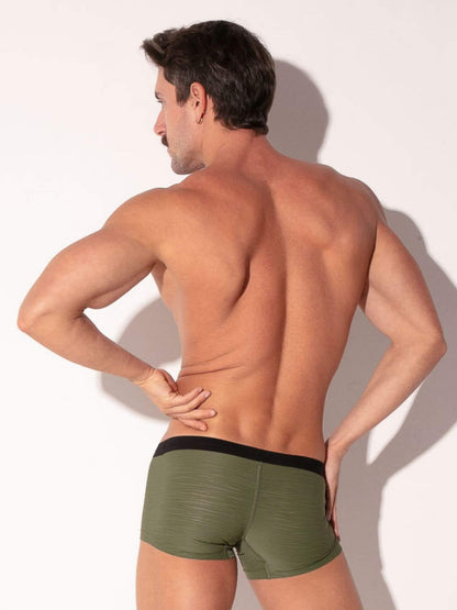 Man wearing green underwear against a plain background