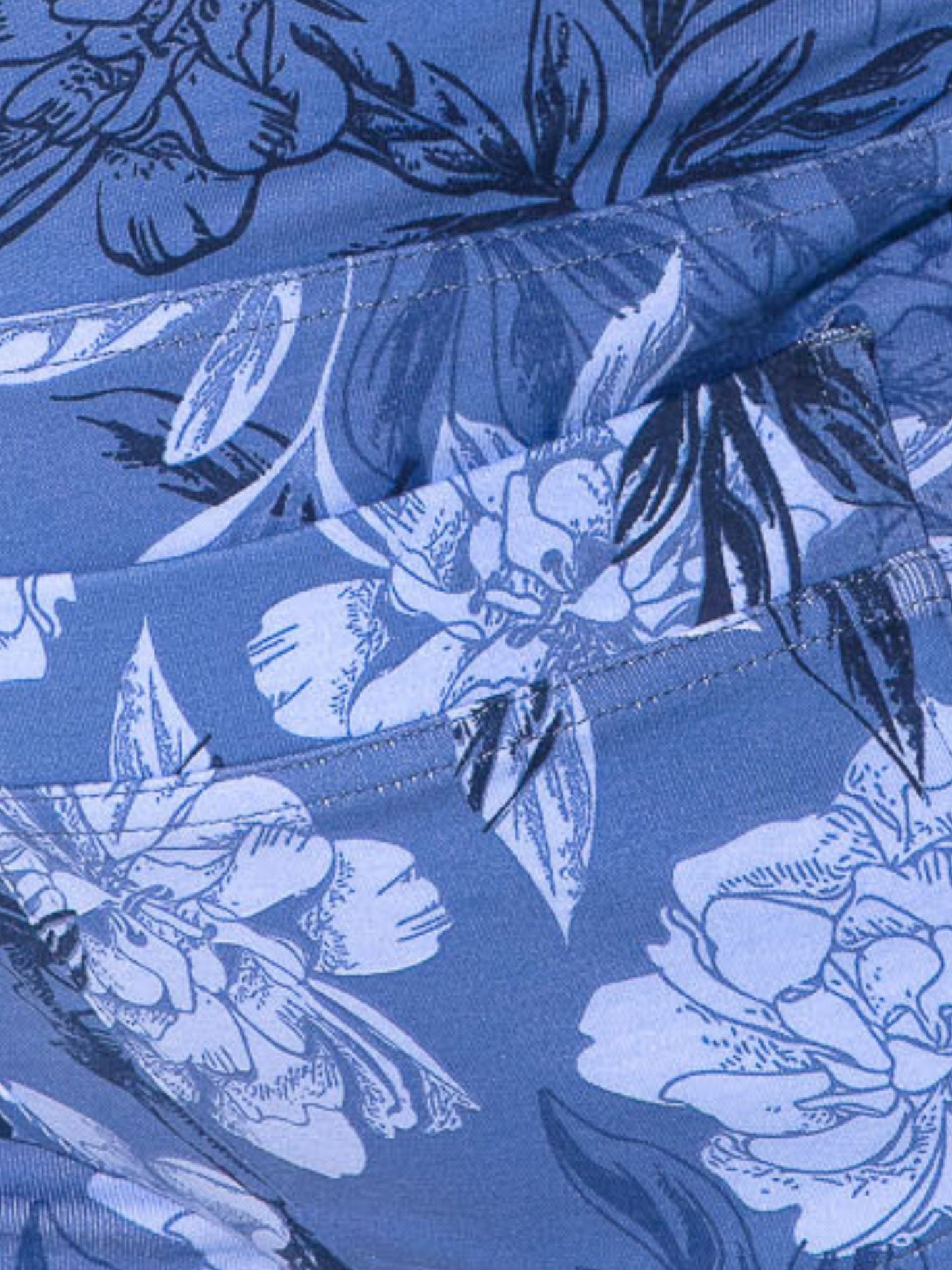Close-up of blue floral fabric with a focus on stitching details