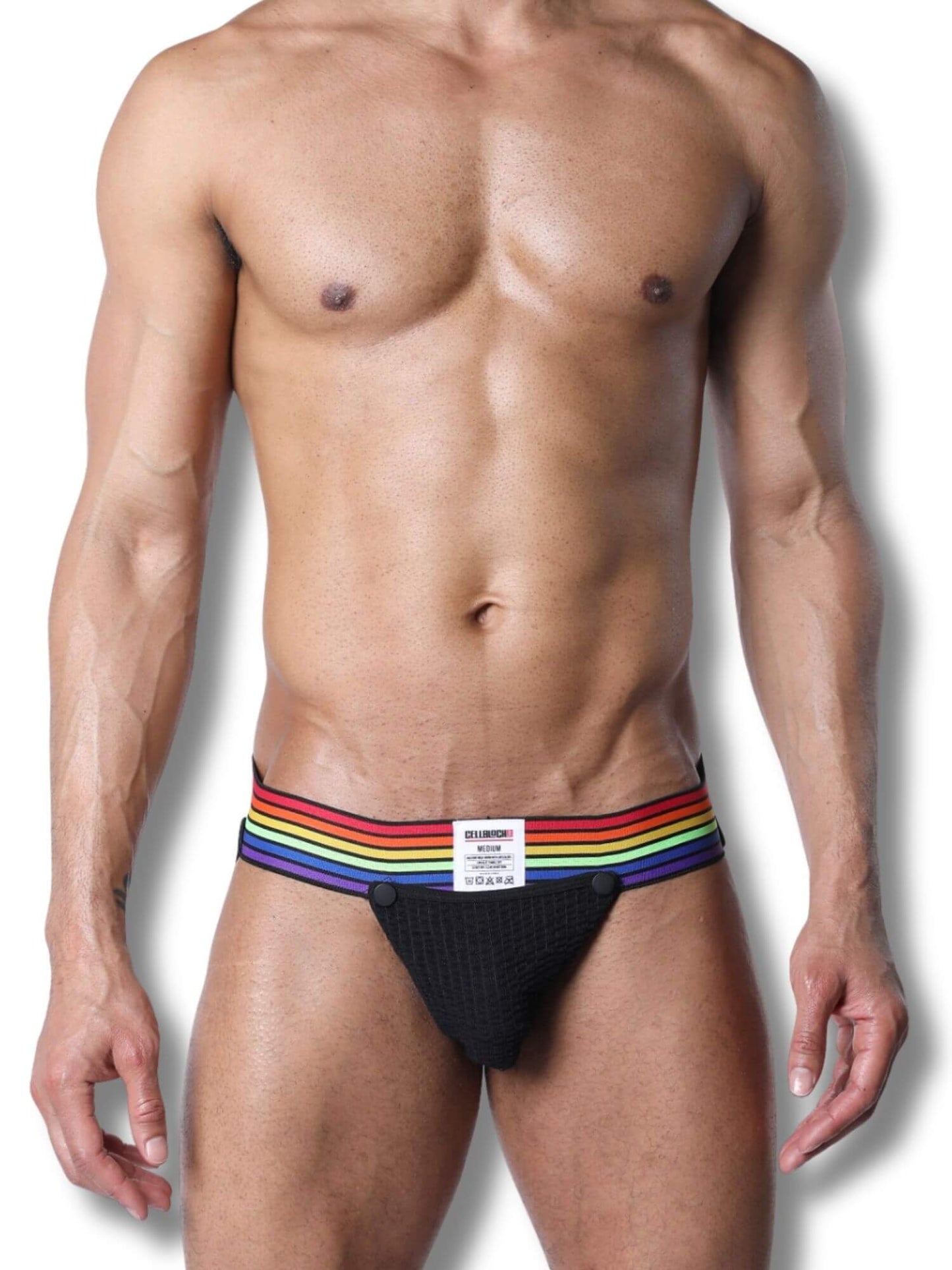 Man wearing a black jockstrap with rainbow stripes on a white background