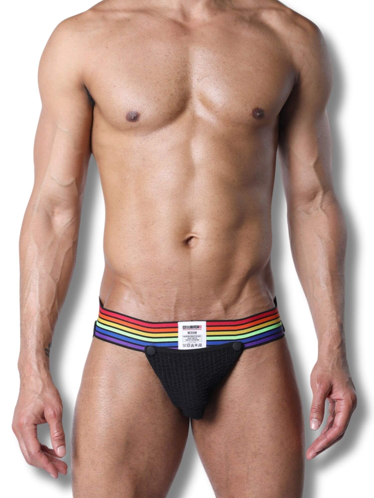 Man wearing a black jockstrap with rainbow stripes on a white background