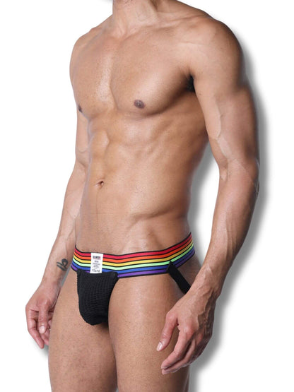 Man wearing a black jockstrap with a rainbow waistband on a white background