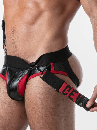 Black and red harness worn by a person on a plain background