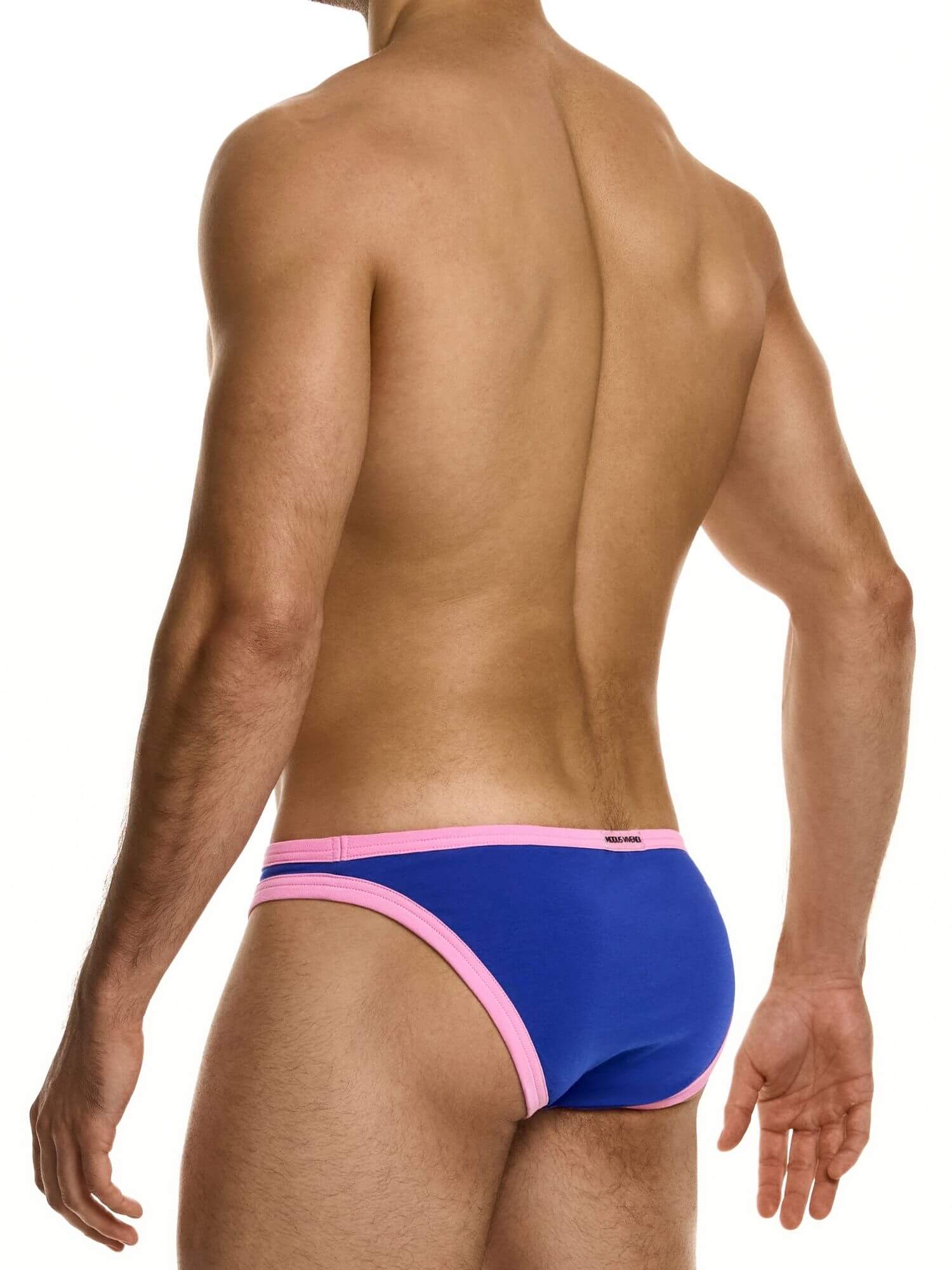 Man wearing blue and pink swim briefs on a white background