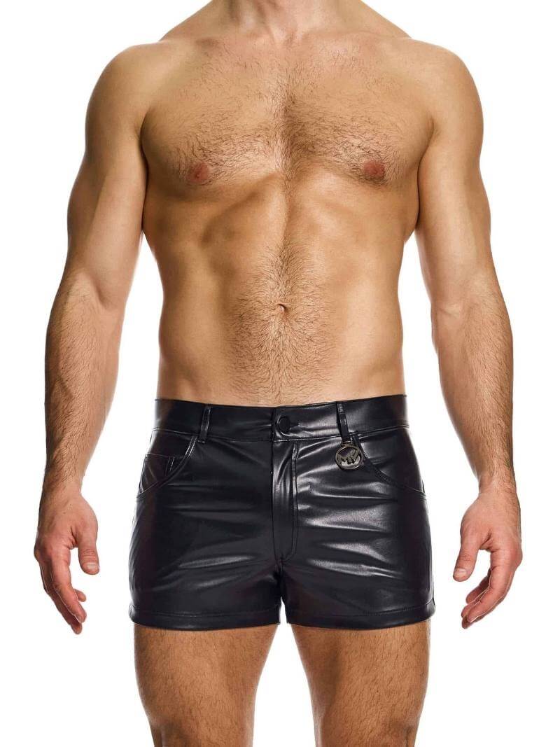 A man wearing black leather-look 5 pocket shorts with a metallic MV logo.