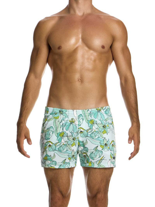 A man wearing art nouveau floral print swim shorts with elastic waistband and side pockets.