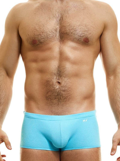 A model wearing blue Brazil-cut boxer underwear with a low-rise waistband and a small MV logo below the waistband.