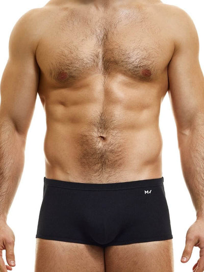 A model wearing blue Brazil-cut boxer underwear with a low-rise waistband and a small MV logo below the waistband.