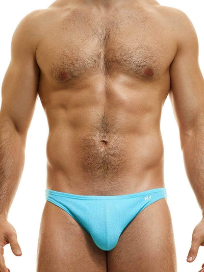 This image features the MODUS VIVENDI Peace low-cut mini brief, showcased in a striking neon blue color. The brief is designed with a super low-rise elastic waist and high-cut legs, creating a modern and flattering silhouette.