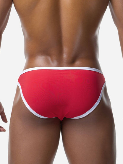 Red men's swim bikini with white waistband on a neutral background