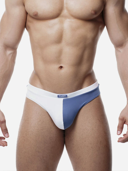 Man wearing a blue and white men's swimming thong on a plain background
