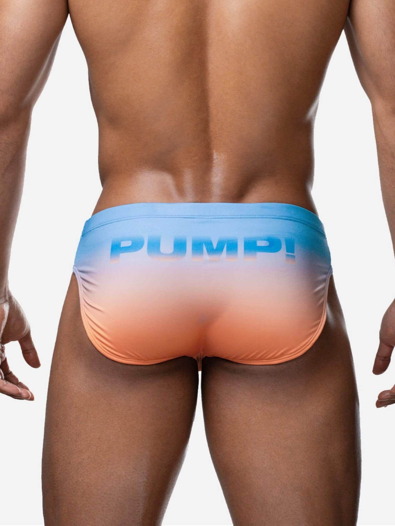 Man wearing a colorful swim brief with 'Pump!' branding on a plain background