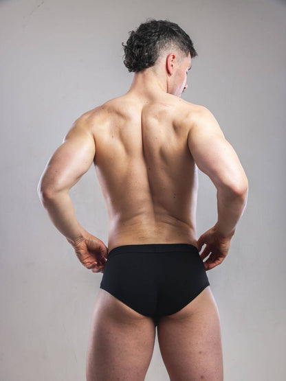 Man wearing a black underwear on a plain background