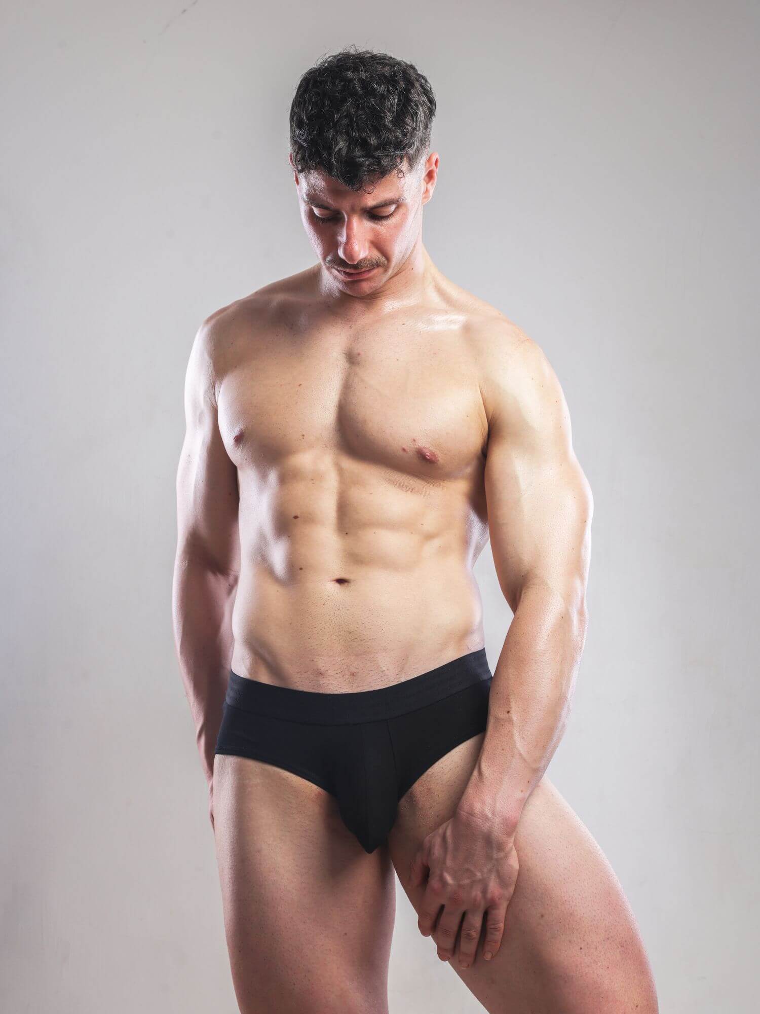 Man wearing a black underwear set against a plain background