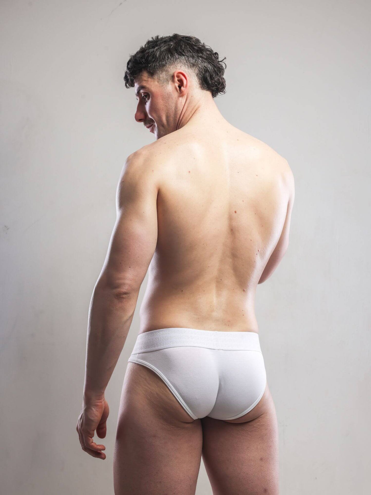 Man wearing a white men's underwear on a plain background
