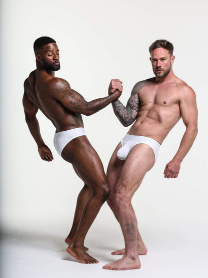 Two men wearing white underwear standing against a plain background