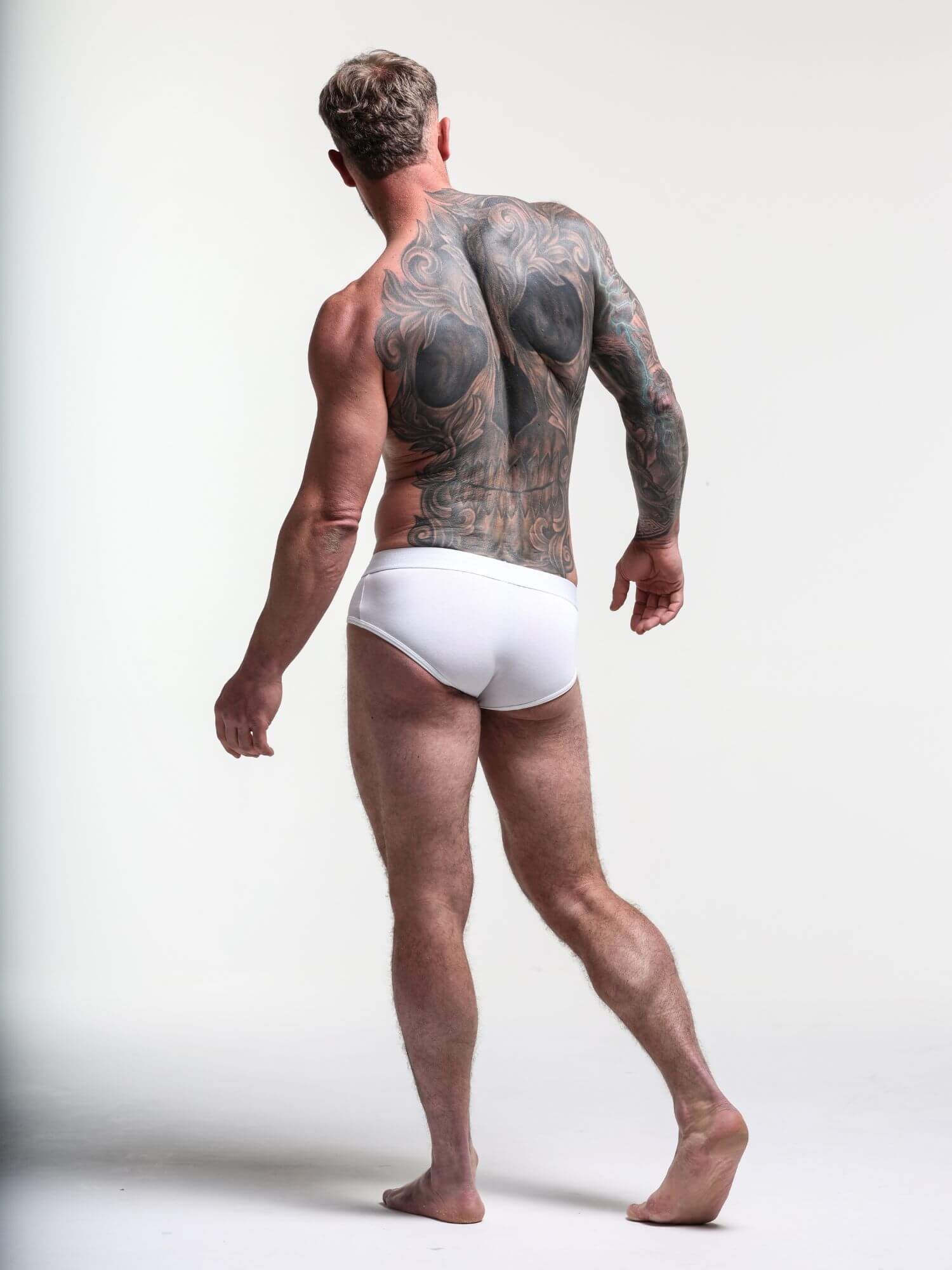 Man wearing white underwear with a plain background