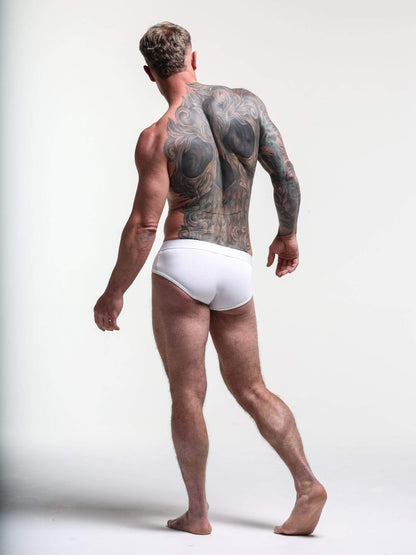 Man wearing white underwear with a plain background