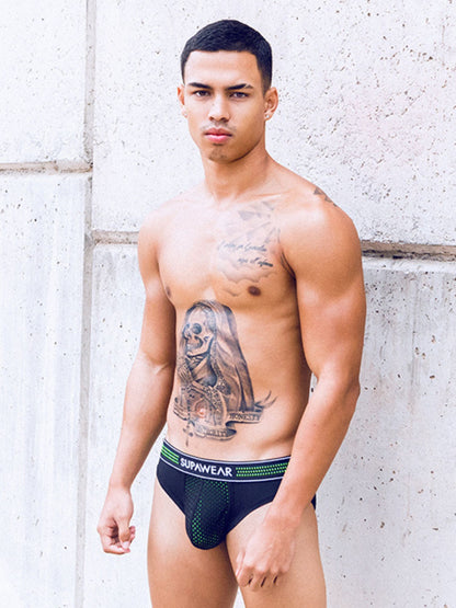 Man wearing black underwear with visible branding against a light-colored wall.
