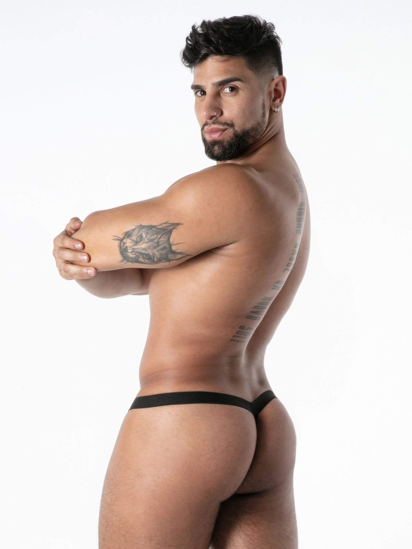 Man wearing a black thong against a white background
