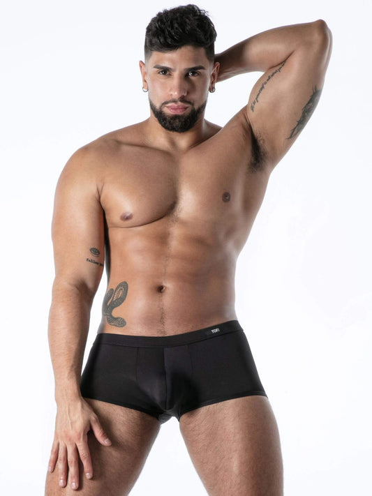 Man wearing black underwear against a white background