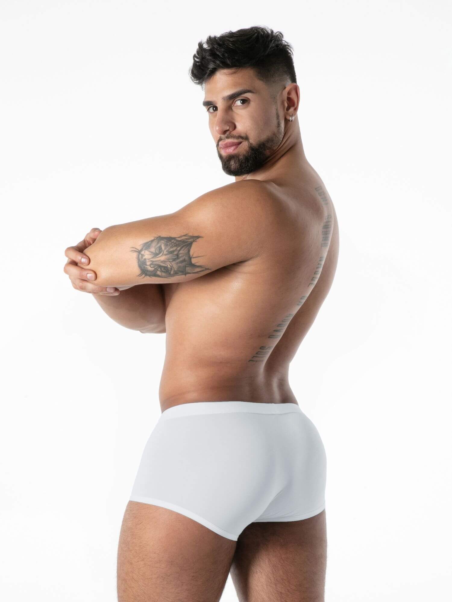 Man wearing white underwear against a plain background