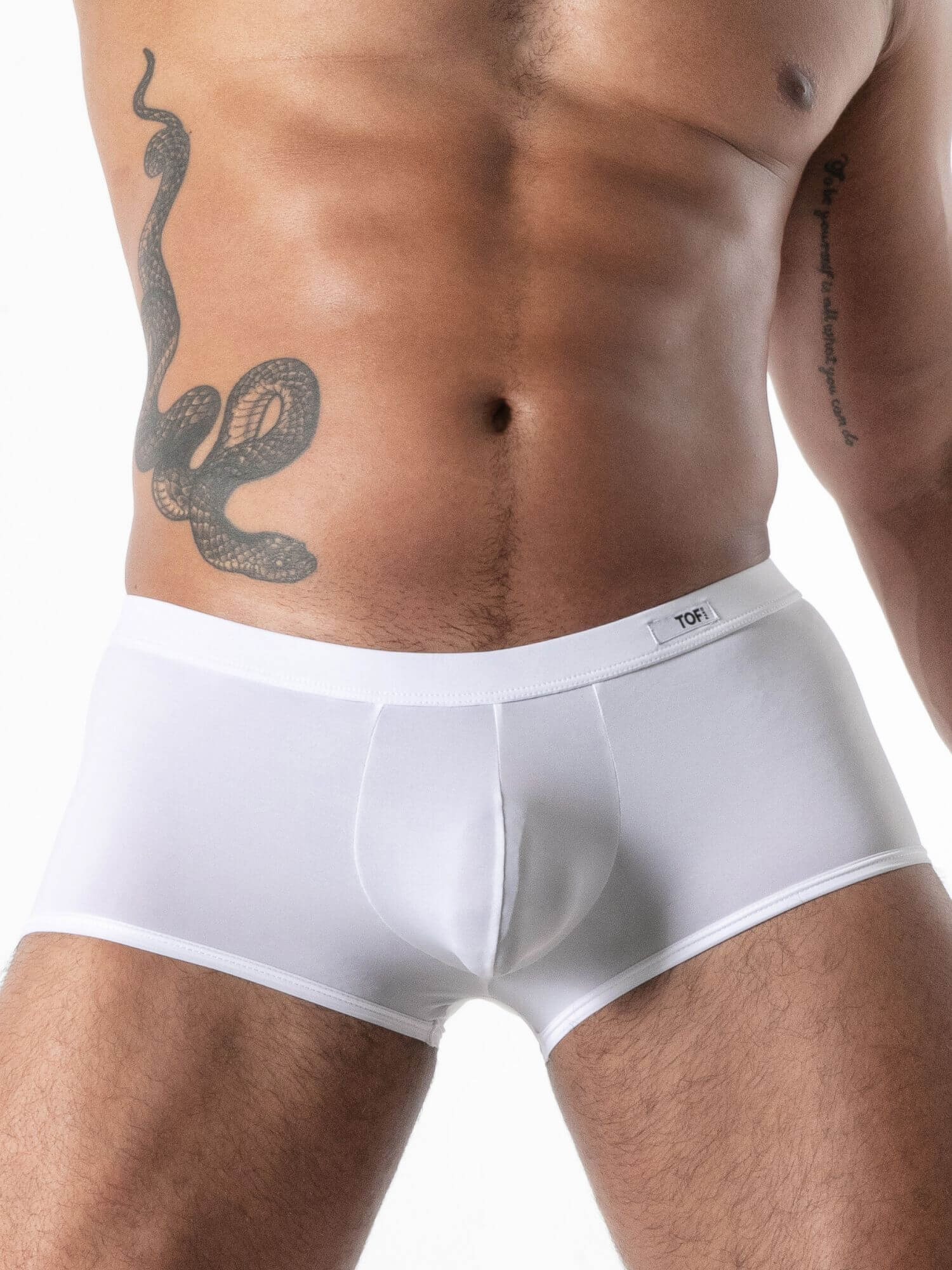 Man wearing white boxer briefs with a snake tattoo on his side.
