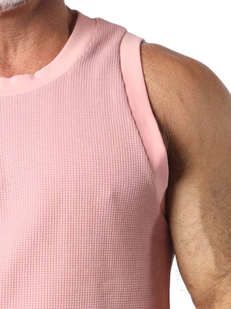 Close-up of a person wearing a pink sleeveless shirt on a white background