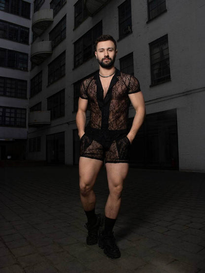 Man wearing a black lace outfit standing in an urban setting