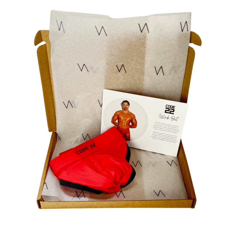 Boxed set with red shorts, black underwear, and a card featuring a man in a swimsuit on a white background.