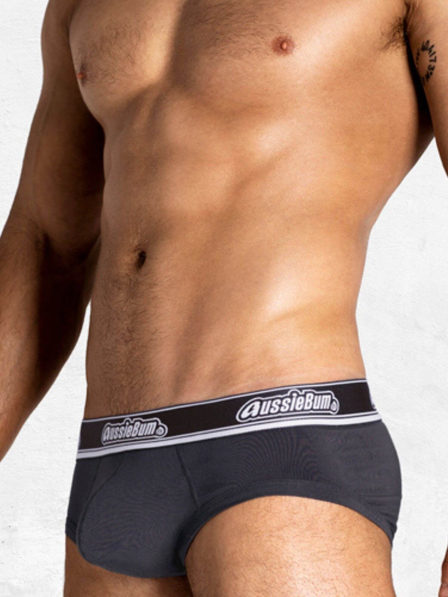 Man wearing navy blue underwear with 'AussieBum' brand logo on a white background