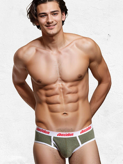Man wearing green underwear with a visible brand logo on a white background