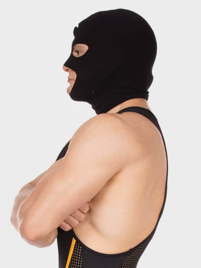 Person wearing a black balaclava and black athletic outfit with yellow accents on a white background