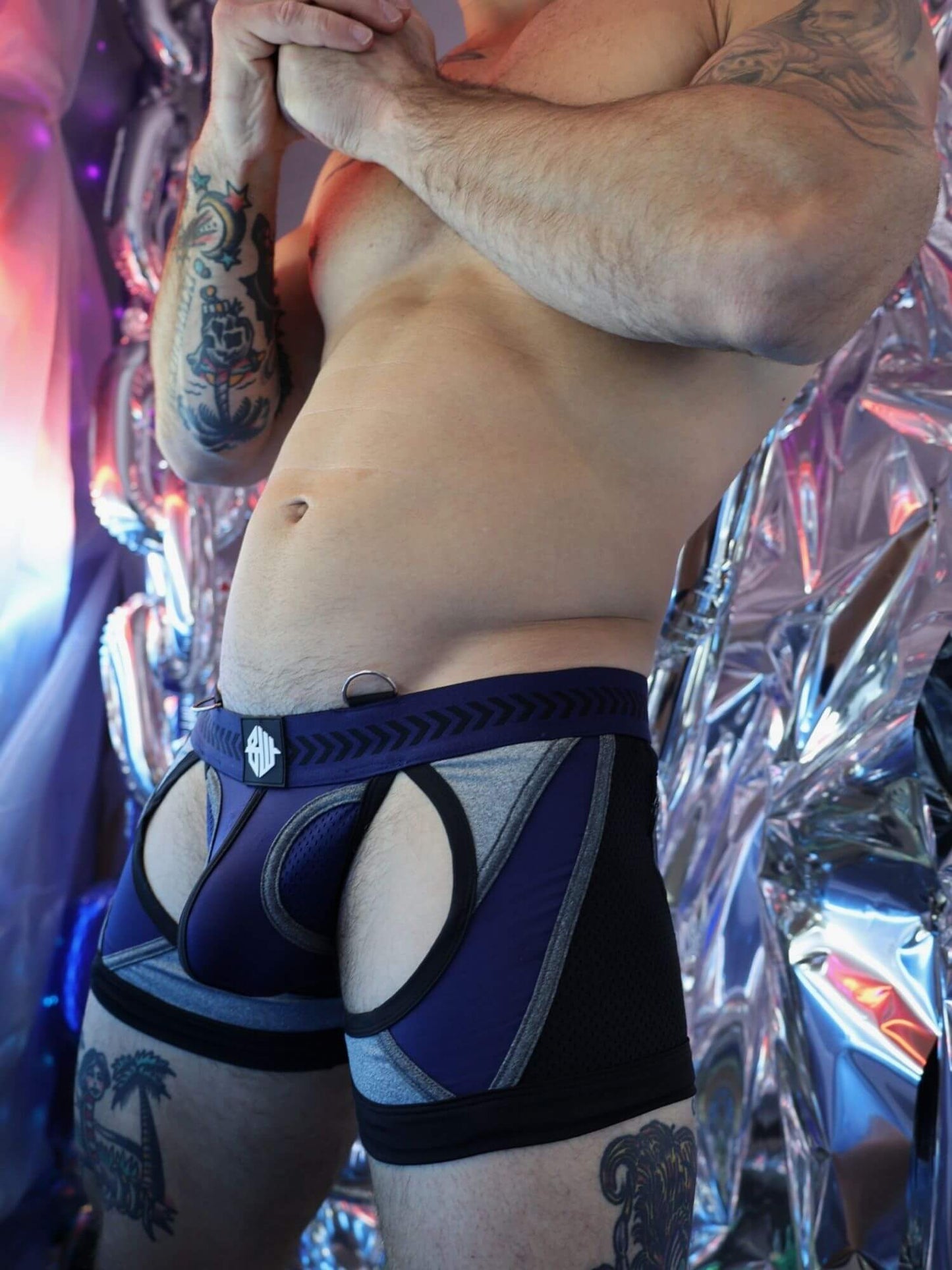 Person wearing a black and blue athletic outfit with tattoos visible on arms and legs.